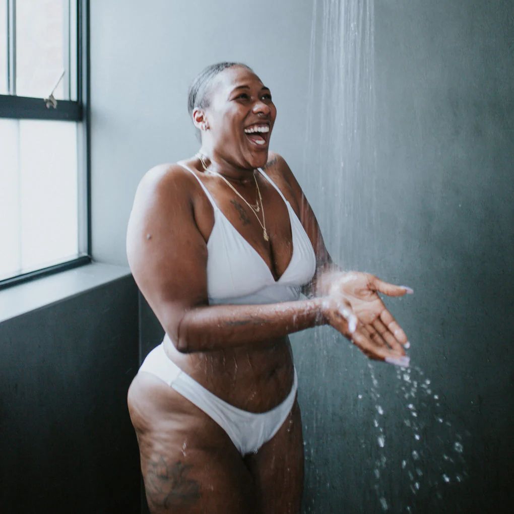 Personne souriante sous une douche froide.