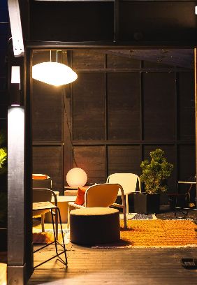 Lounge intérieur chaleureux avec fauteuils et lumière douce.