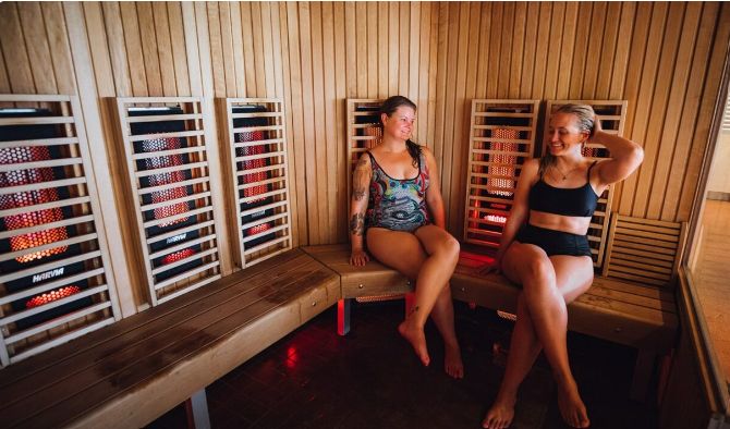 Deux personnes assises dans un sauna infrarouge.